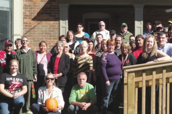 Group of people posing for a photo in front of a house